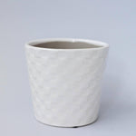 A white ceramic flower pot with an embossed square pattern.