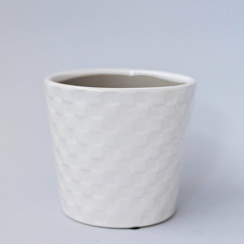 A white ceramic flower pot with an embossed square pattern.