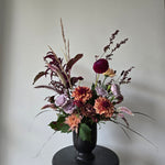 Autumnal vase arrangement in black pedestal pot