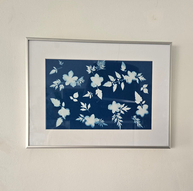 Framed artwork with white floral design on a blue background