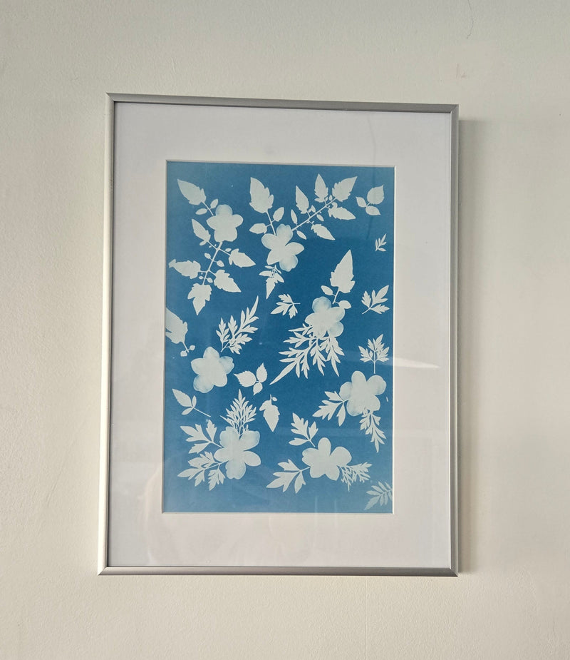Framed floral artwork on a plain wall
