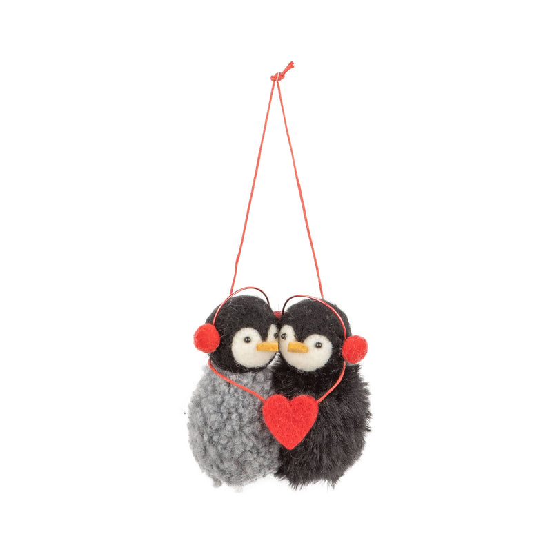 Two fluffy penguin ornaments with a red heart and headphones on a white background