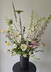 Floral arrangement in a black vase on a gray background