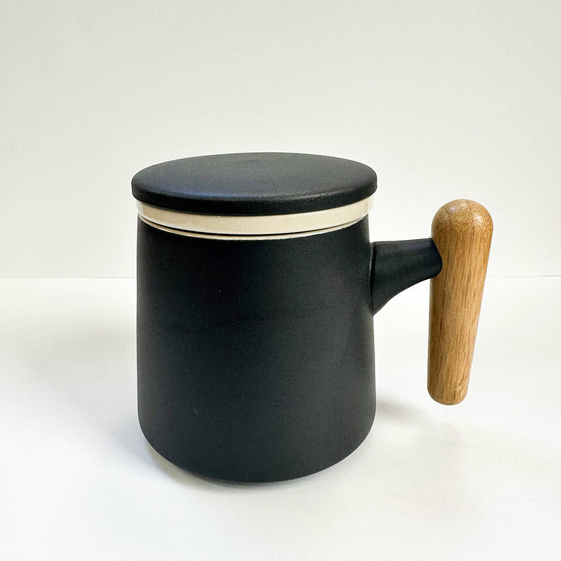Black mug with a wooden handle on a white background