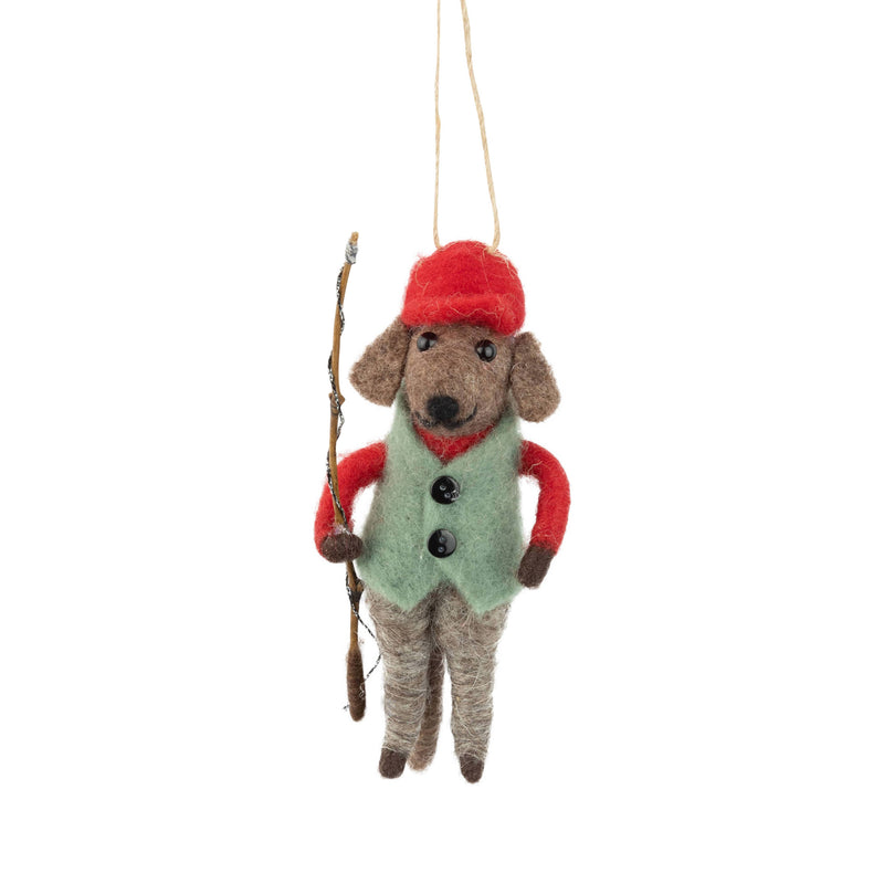Felted animal ornament resembling a dog wearing a red hat and green vest, holding a stick, on a white background.