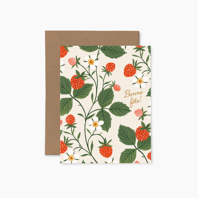 A folded greeting card with a floral design featuring strawberries and the text 'Bonne fête' on the front, accompanied by an envelope with a brown flap.